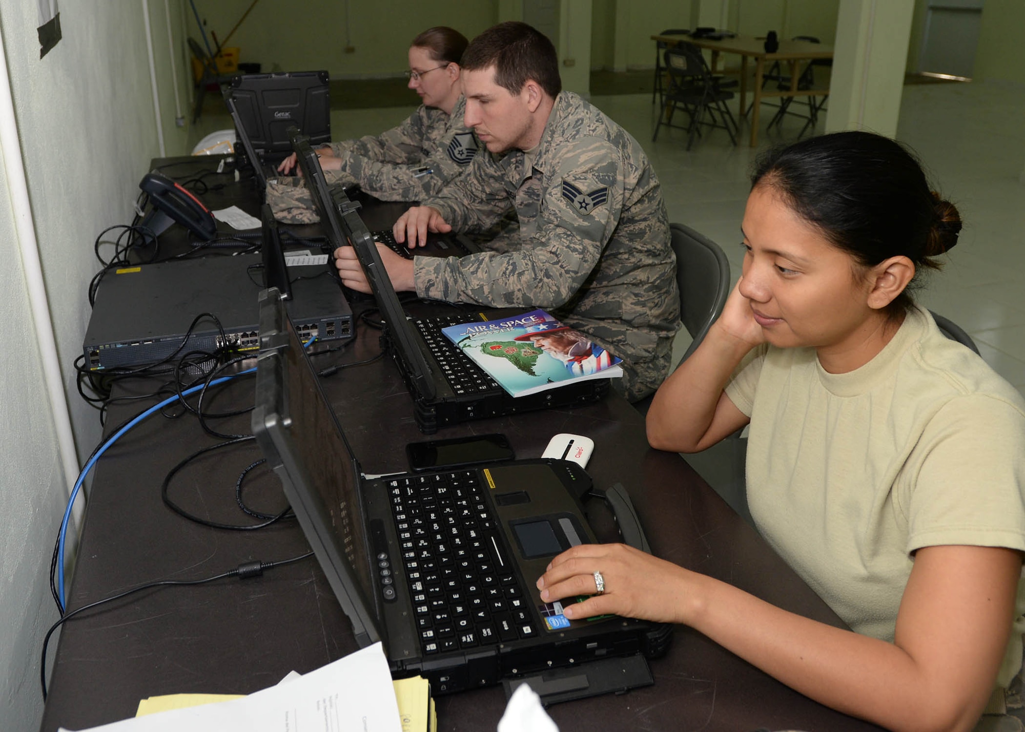 U.S. Airmen participating in NEW HORIZONS 2017 use government laptops as Senior Airman Joshua Marsh, a cyber systems operator with the 51st Combat Communications Squadron (CCS) out of Robins Air Force Base, Ga., center, fixes a software problem in Arroyo Cano, Dominican Republic, April 13, 2017. U.S. Service members supporting NEW HORIZONS 2017 are provided with access to government computer, phone lines and wireless routers by the 51st CCS to complete their missions. (U.S. Air Force photo by Staff Sgt. Timothy M. Young)