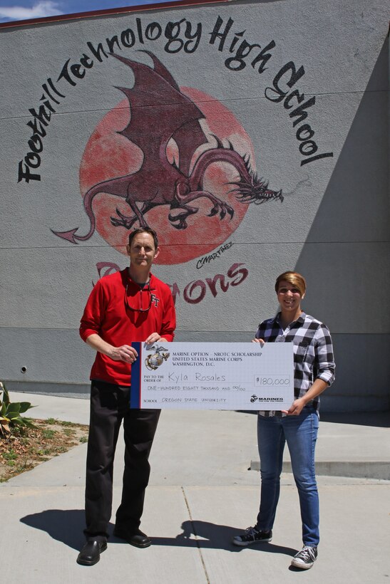 Foothill Technology High School Principal Joe Bova and Kyla Rosales pose for a photo after Sergeant Brian Robert, recruiter of Recruiting Sub Station Ventura, presented a Naval Reserve Officers Training Corps Scholarship check to Kyla at the high school, April 26, 2017. (U.S. Marine Corps photo by Staff Sgt. Alicia R. Leaders/Released)