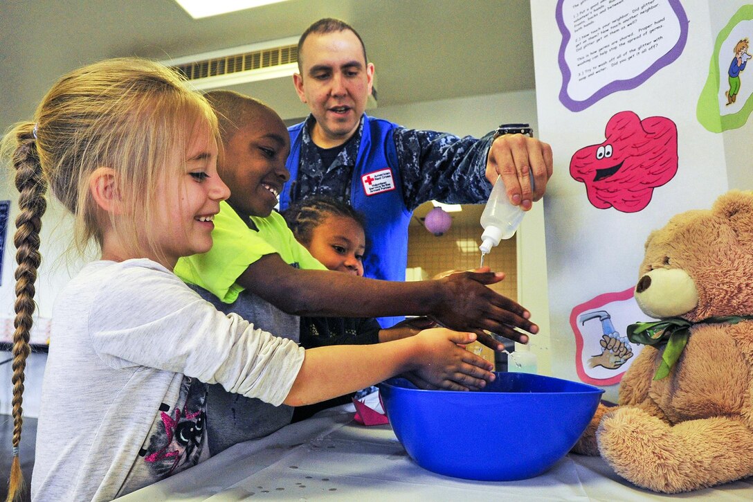 Navy Petty Officer 1st Class Brandon Dacosta teaches children how to properly wash their hands during a Month of the Military Child event in Yokosuka, Japan, April 24, 2017. Navy photo by Petty Officer Seaman Patrick Semales