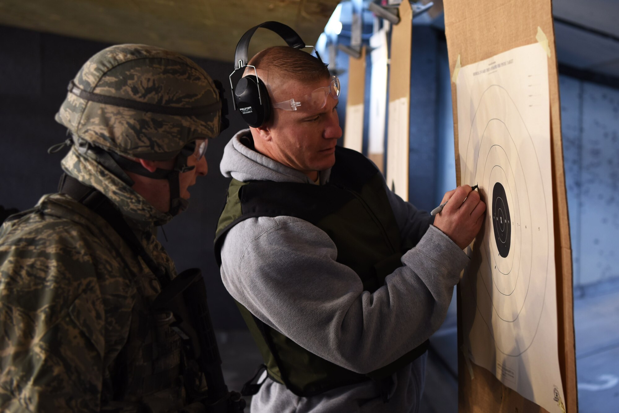 Jason Spillis, Adams County Sheriff Department detective and U.S. Air Force reservist, marks missed shots for Airman 1st Class Alexander Warren, 460th Security Forces Squadron member, as he zeroes in the sight on his rifle, Apr. 22, 2017, at the Flatrock Regional Training Center in Commerce City, Colo. After zeroing in their sights, each SFS member fired at their target while changing shooting positions, and while maneuvering tactically. (U.S. Air Force photo by Airman 1st Class Holden S. Faul/ Released)