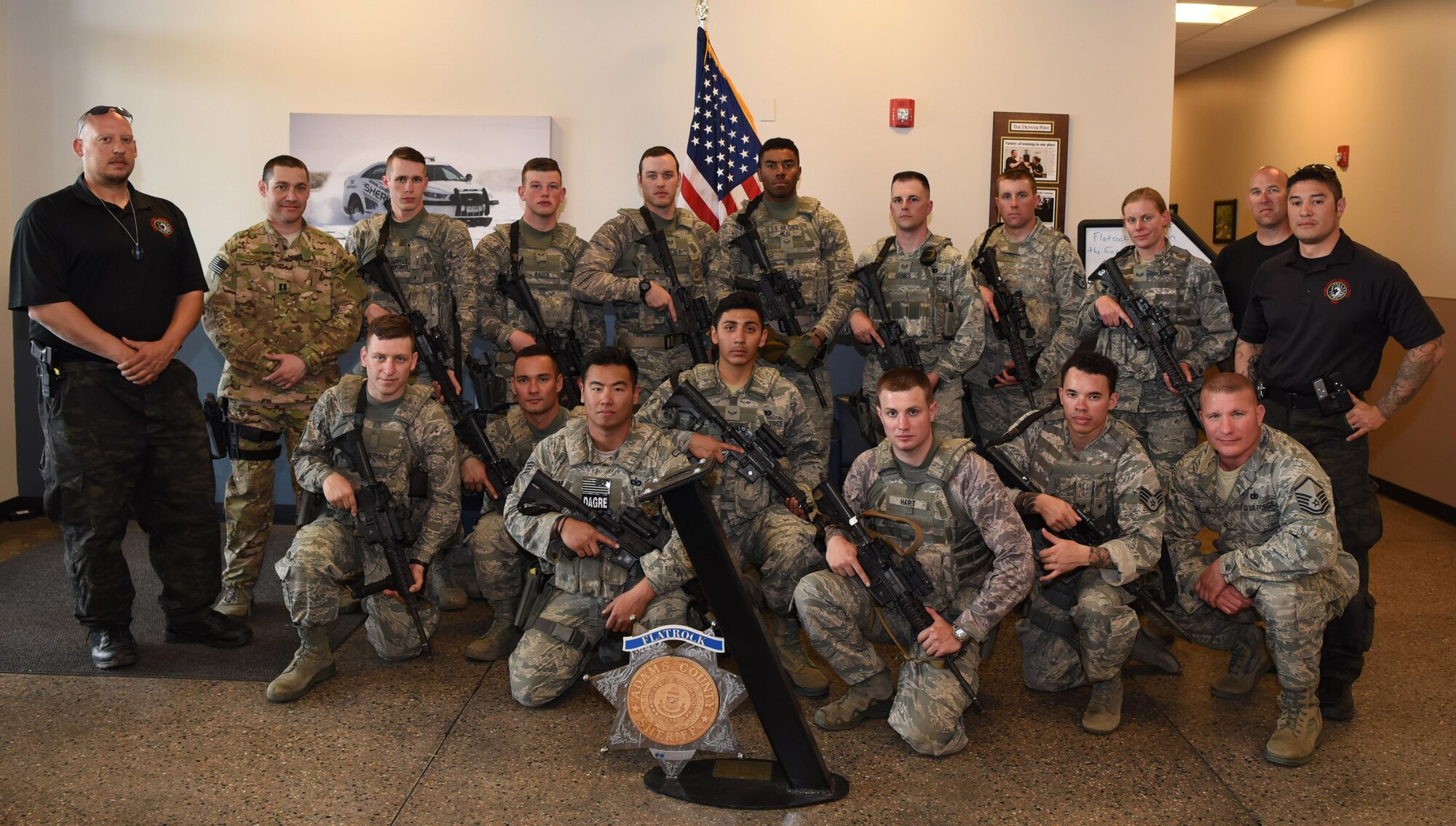 Members from the 460th Security Forces Squadron, the 302nd SFS and Adams County Sheriff Department pose for a group photo Apr. 23, 2017, at the Flatrock Regional Training Center in Commerce City, Colo. Adams County Sheriff Department Special Weapons and Tactics team spent three days training the 460th SFS Emergency Services Team in tactical movements for several possible scenarios. (U.S. Air Force photo by Airman 1st Class Holden S. Faul/ Released)