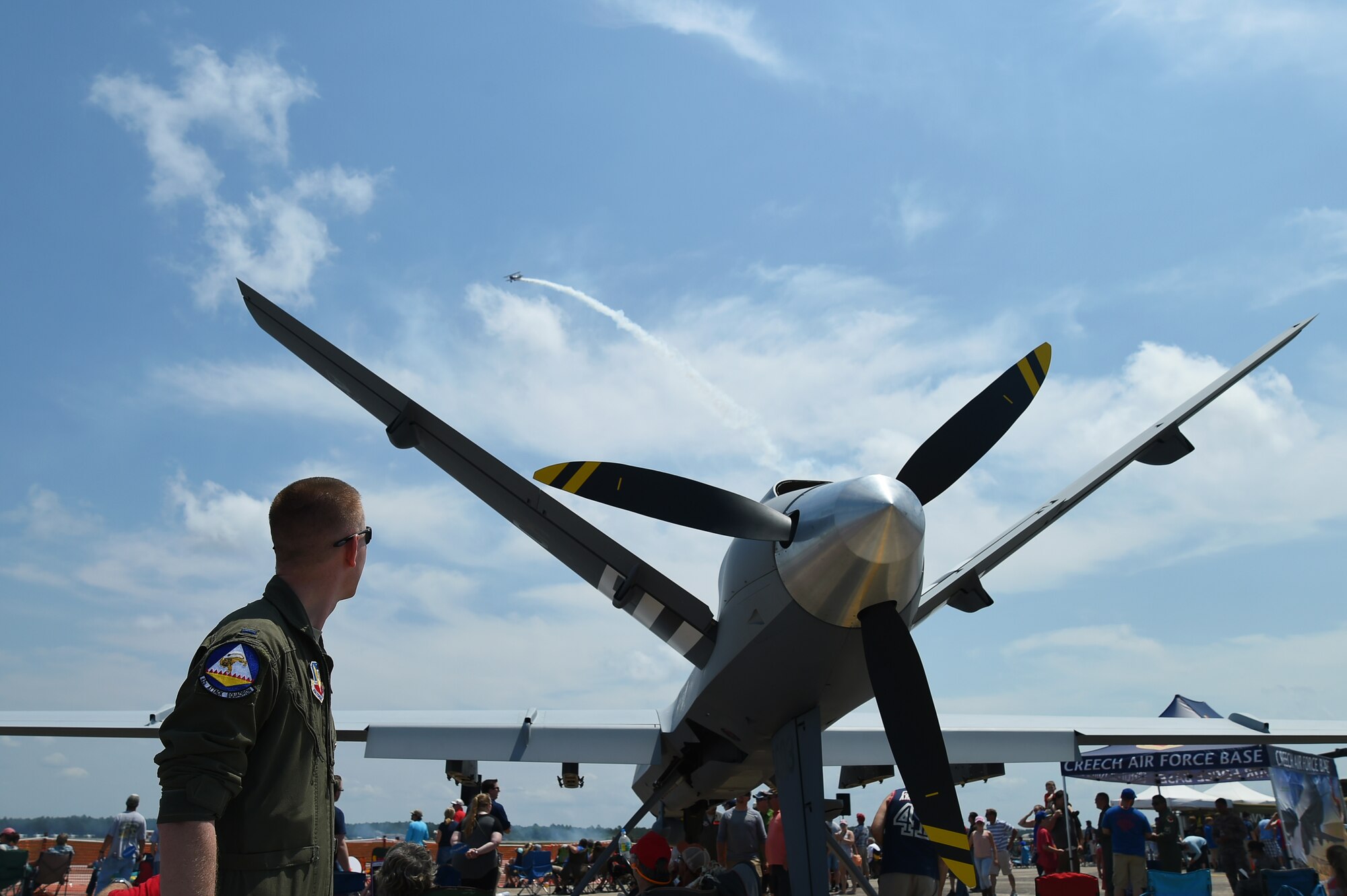 An Airman assigned to the 432nd Wing/432nd Air Expeditionary Wing watches one of the air demonstrations performed during the 2017 Gulf Coast Salute Open House and Airshow April 22, 2017, at Tyndall Air Force Base, Fla. Airmen from Creech Air Force Base, Nev., debuted the model at the air show and were able to communicate the MQ-9’s capability and mission sets to visitors. (U.S. Air Force photo/Airman 1st Class James Thompson)