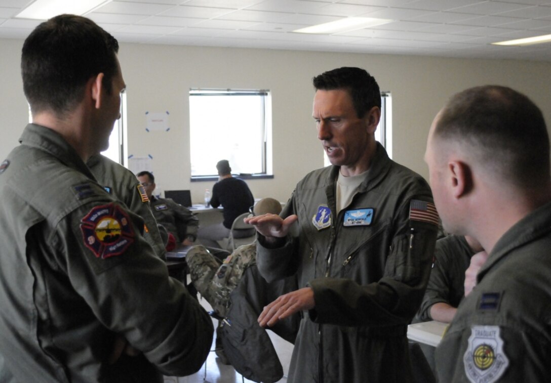 Wyoming Air National Guard Lt. Col. Ryan Scofield, Modular Airborne Fire Fighting System instructor pilot, discusses an upcoming training sortie with members of Nevada Air National Guard's 152nd Airlift Wing. Members of all four MAFFS-designated wings came together for annual certification and training in Boise, Idaho April 19-24, 2017. (Photo by: U.S. Air National Guard Master Sgt. Daniel Butterfield) 