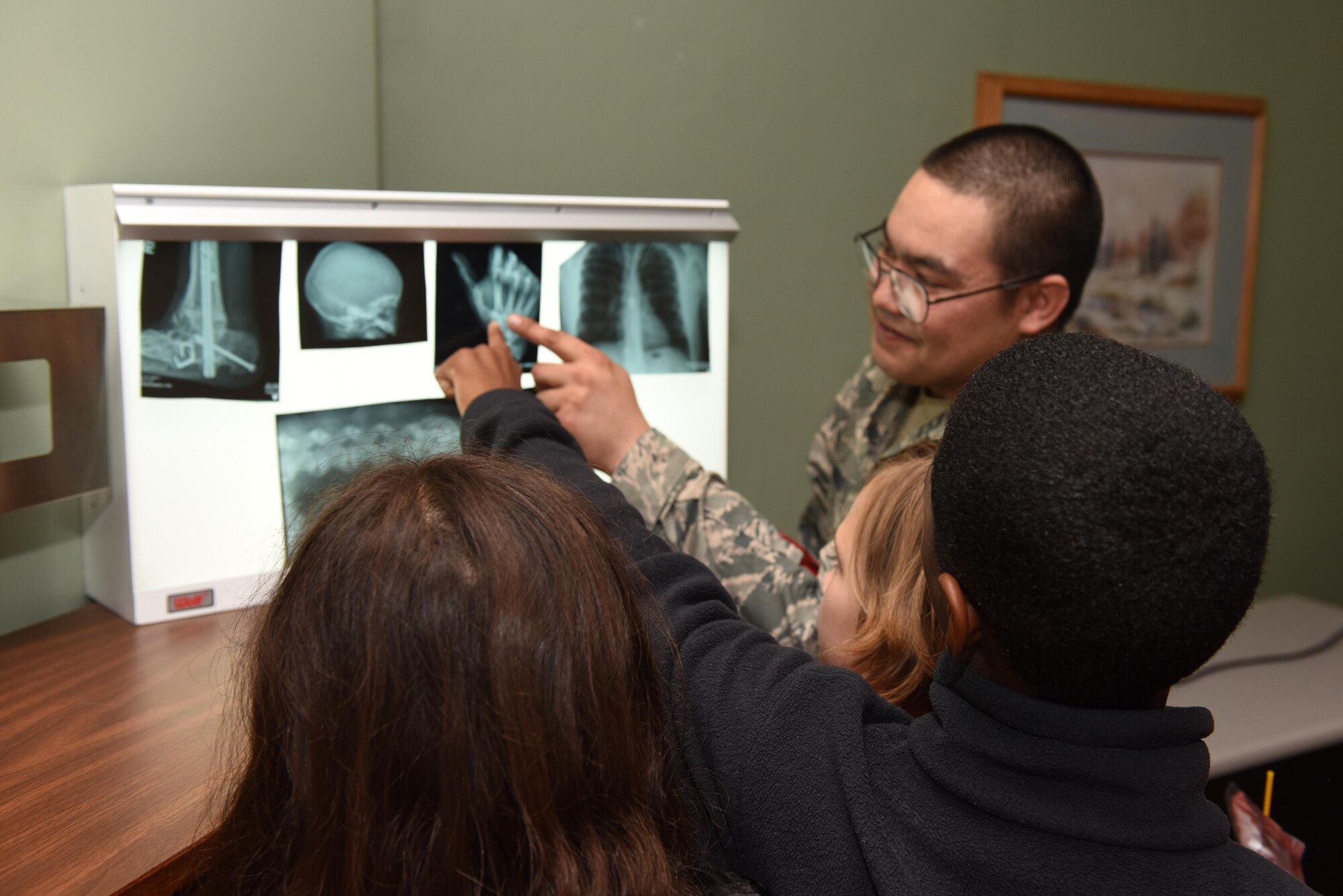 Staff Sgt. Matthew Baker, 30th Medical Group diagnostic imaging technician, shows children training X-ray images during Take Your Child to Work Day, April 27, 2017, Vandenberg Air Force Base, Calif. Take Your Child to Work Day is the first annual trial of the program, which gives military youth an opportunity to see what their parents contribute to the space and missile mission. (U.S. Air Force photo by Senior Airman Robert J. Volio/Released)