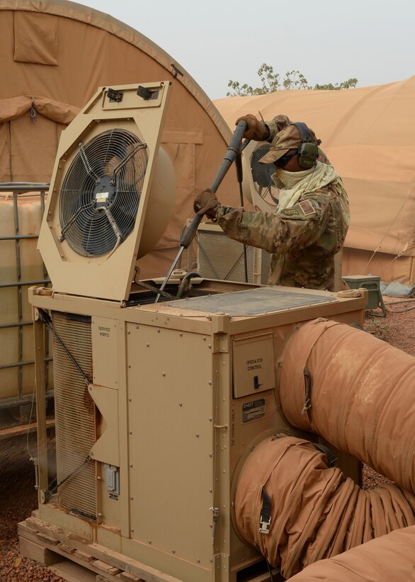 Staff Sgt. Julian Johnson, 768th Expeditionary Air Base Squadron NCO in charge of Heating Ventilation and Air Conditioning, cleans an HVAC unit at Nigerien Air Base 101, Niger, April 3, 2017. While cleaning the units, HVAC members spray the inside and outside of units, pull out and clean the air filters, and perform a systems check once finished. (U.S. Air Force photo by Senior Airman Jimmie D. Pike)