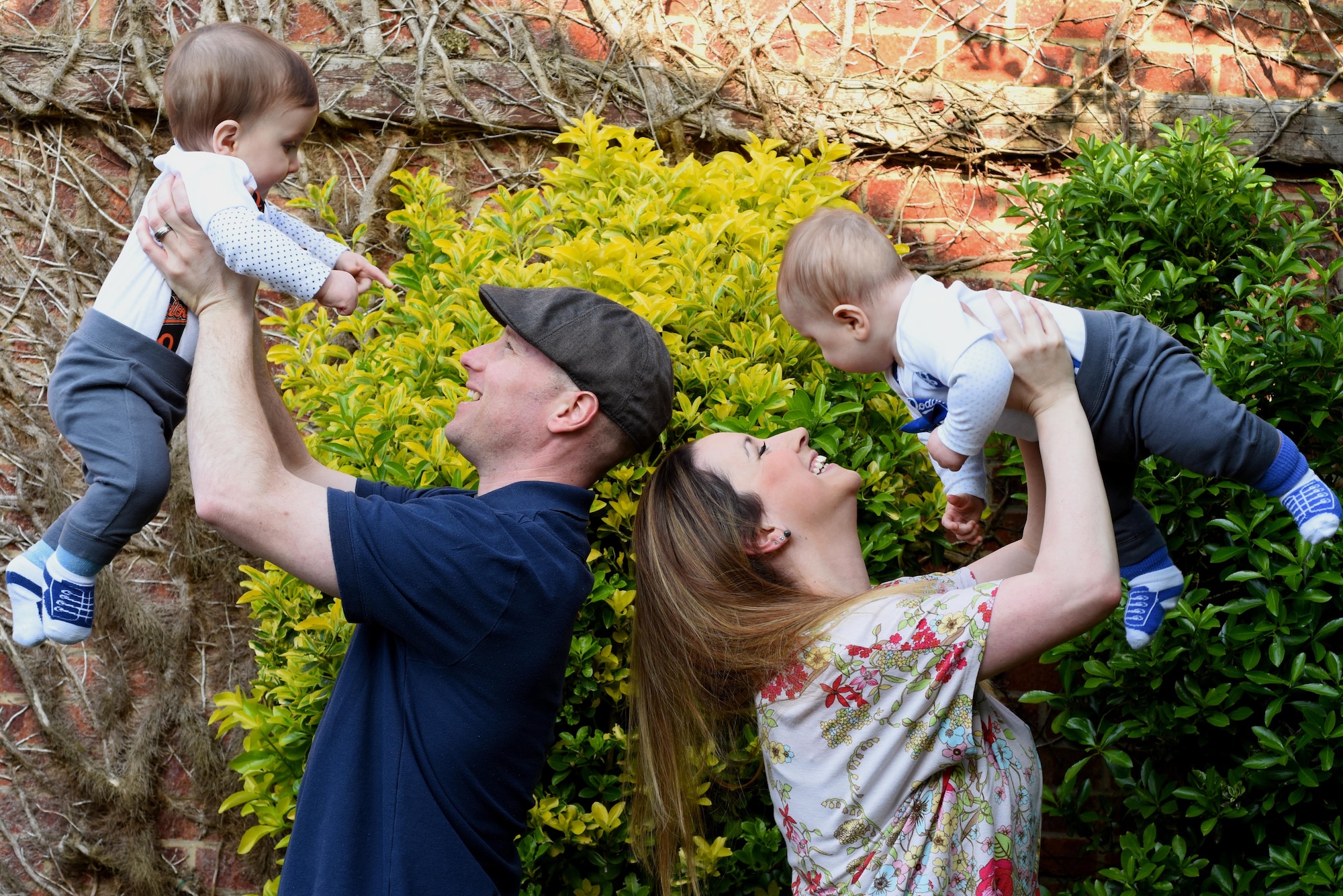 Kate and her husband lift their twin 10-month-old boys into the air. Therapy helped Kate, a military spouse, mother and nurse, heal the scars left by abuse. (U.S. Air Force photo/Airman 1st Class Abby L. Finkel)