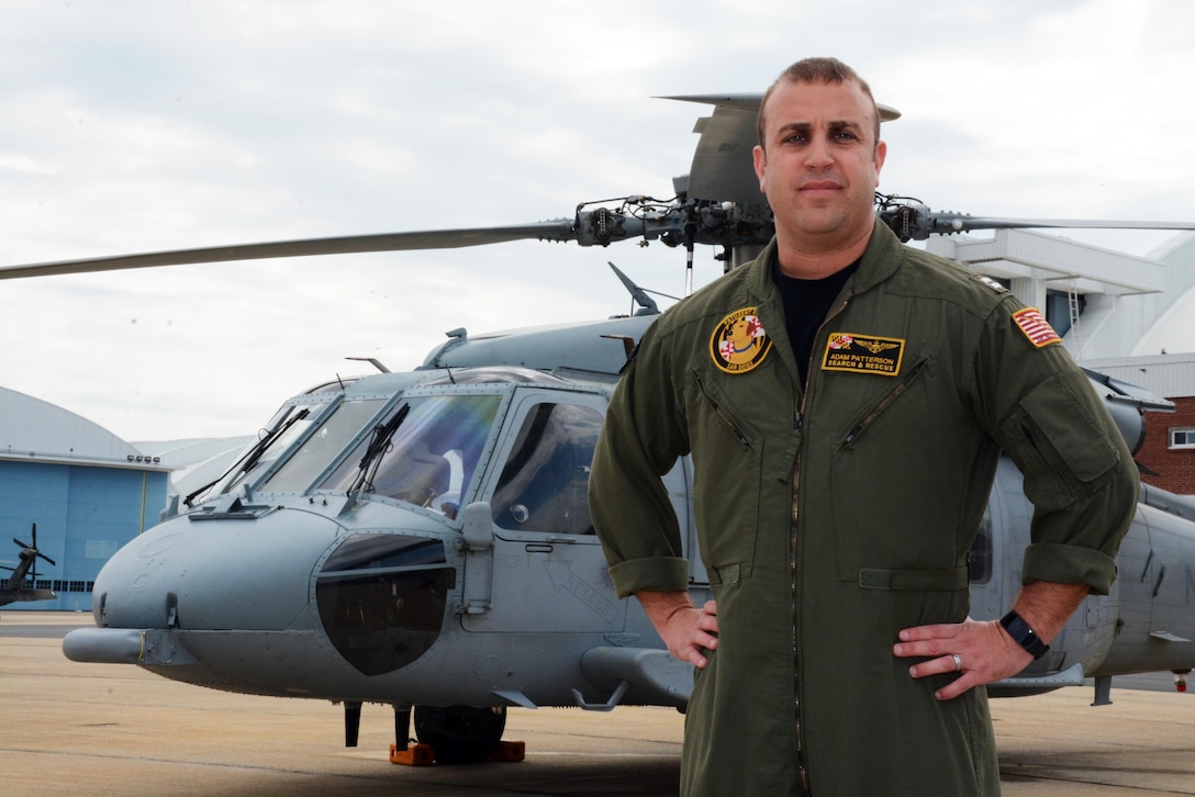Navy Lt. Adam Patterson stands in front of one of the MH-60S Seahawk helicopters he flies as a pilot with Naval Air Station Patuxent River's search-and-rescue team, at NAS Patuxent River, Md., April 14, 2017. Patterson's Navy career has taken him above and below the sea. Navy photo by Petty Officer 1st Class Patrick Gordon