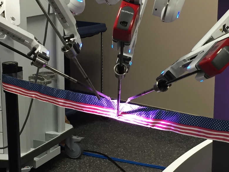 The da Vinci Xi surgical robotic system, operated by Maj. (Dr.) Toby Lees, urologist, performs the ceremonial ribbon cutting. (Skywrighter photo/Amy Rollins)