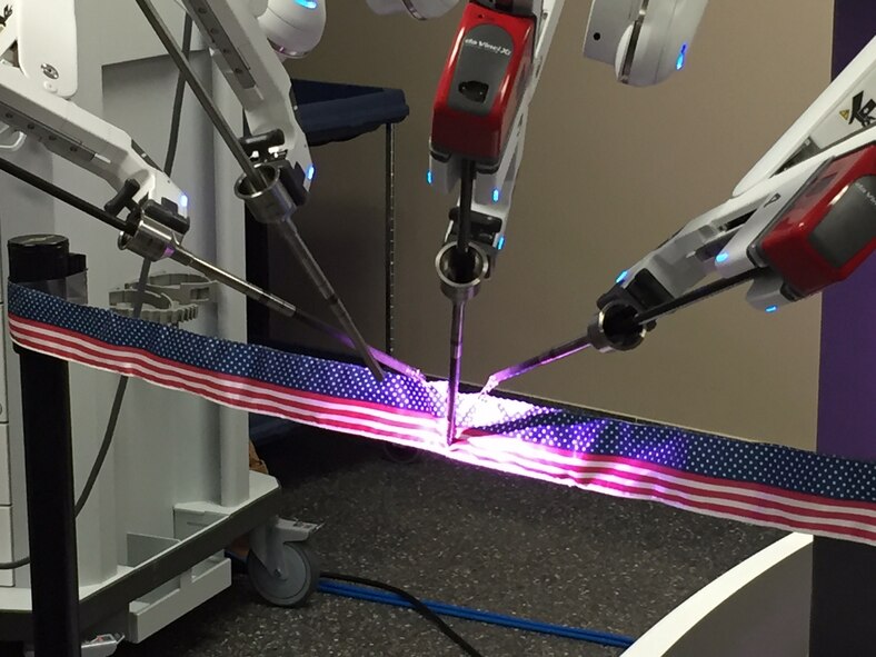 The da Vinci Xi surgical robotic system, operated by Maj. (Dr.) Toby Lees, urologist, performs the ceremonial ribbon cutting. (Skywrighter photo/Amy Rollins)