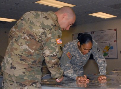 Sgt. 1st Class Michael Giarrusso, a 42nd Infantry Division operations NCO, and Staff Sgt. Diahann Adepegba, a division intelligence NCO in-charge, map out a 10-mile radius of a simulated nuclear blast area in order to identify affected roads and bridges during Ardent Sentry 17 at the 42nd Infantry Division's Troy, N.Y., armory on April 26, 2017.