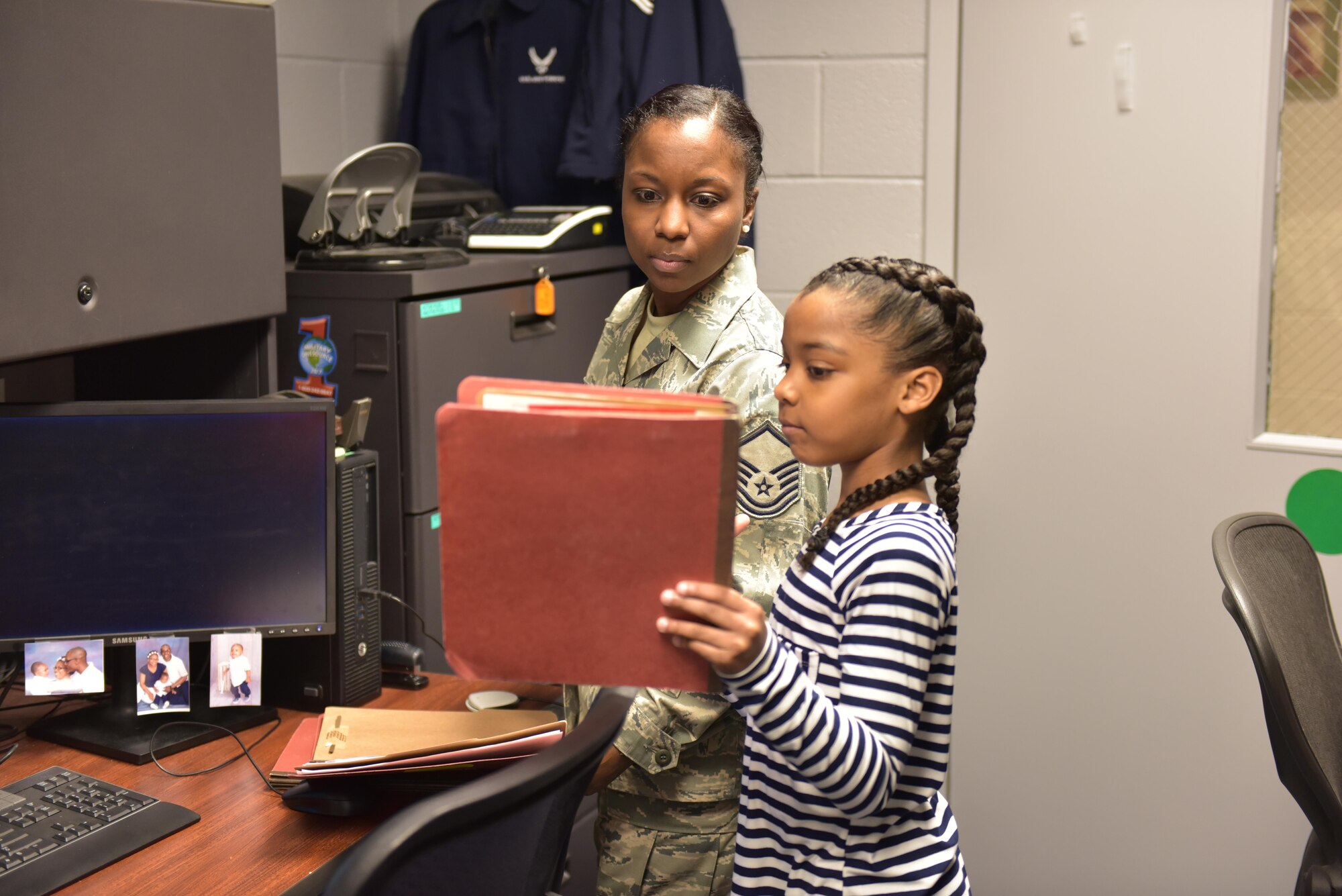 April is designated as the Month of the Military Child, underscoring the important role military children play in the armed forces community. The Month of the Military Child helps raise awareness about the unique struggles military children face, builds resiliency to help them cope with those challenges, and celebrates their sacrifices, which often go unrecognized. Master Sgt. Chastity Morgan, a knowledge operations specialist assigned to the 180th Fighter Wing, and her daughter file personnel mobilization folders at the wing, March 10, 2017 Air National Guard Photo by Tech. Sgt. Nic Kuetemeyer.