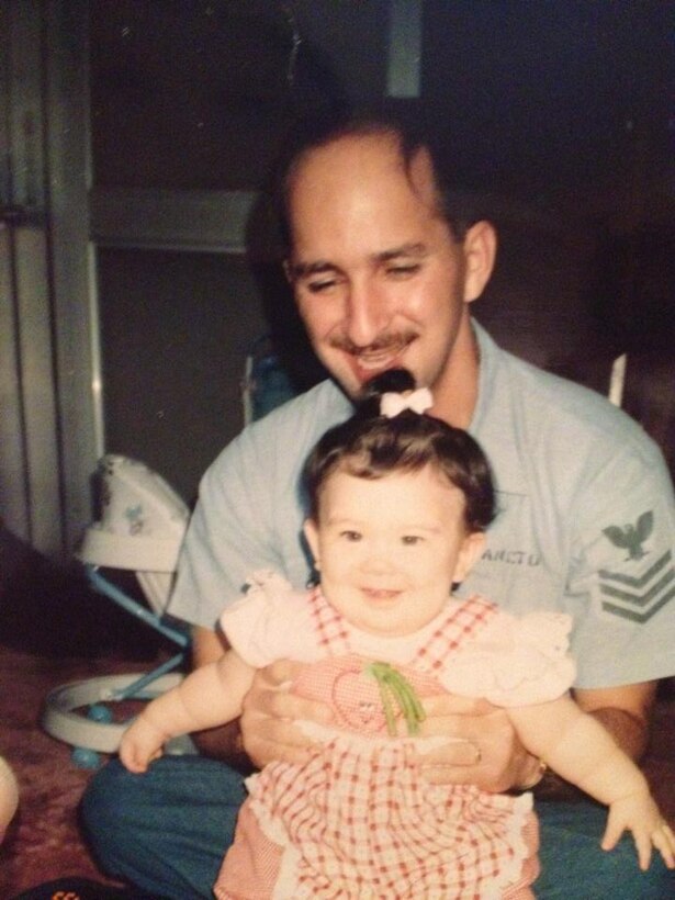 U.S. Air Force Airman 1st Class April Lancto, 7th Bomb Wing Public Affairs photojournalist, is held by her father, Mark, pictured at about eight months old in 1991. Lancto was a military child who dreamt about joining the military since she was five and in 2015, she made her dreams come true and enlisted into the Air Force. (Courtesy photo)