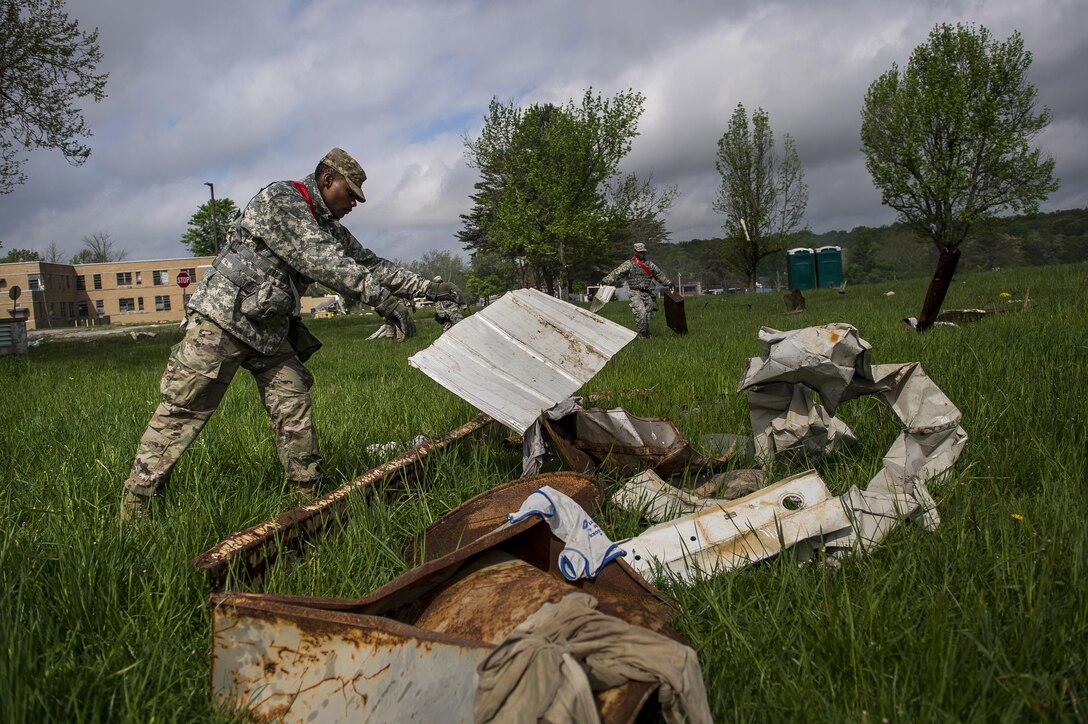 U.S. Army Soldiers from the 51st Chemical Biological Radiological Nuclear Company, of Fort Stewart, Georgia, clear a field from debris to set up a decontamination tent during Guardian Response 17 at the Muscatatuck Urban Training Center, Indiana, April 27, 2017. Guardian Response, as part of Vibrant Response, is a multi-component training exercise run by the U.S. Army Reserve designed to validate nearly 4,000 service members in Defense Support of Civil Authorities (DSCA) in the event of a Chemical, Biological, Radiological and Nuclear (CBRN) catastrophe. This year's exercise simulated an improvised nuclear device explosion with a source region electromagnetic pulse (SREMP) out to more than 4 miles. The 84th Training Command is the hosting organization for this exercise, with the training operations run by the 78th Training Division, headquartered in Fort Dix, New Jersey. (U.S. Army Reserve photo by Master Sgt. Michel Sauret)