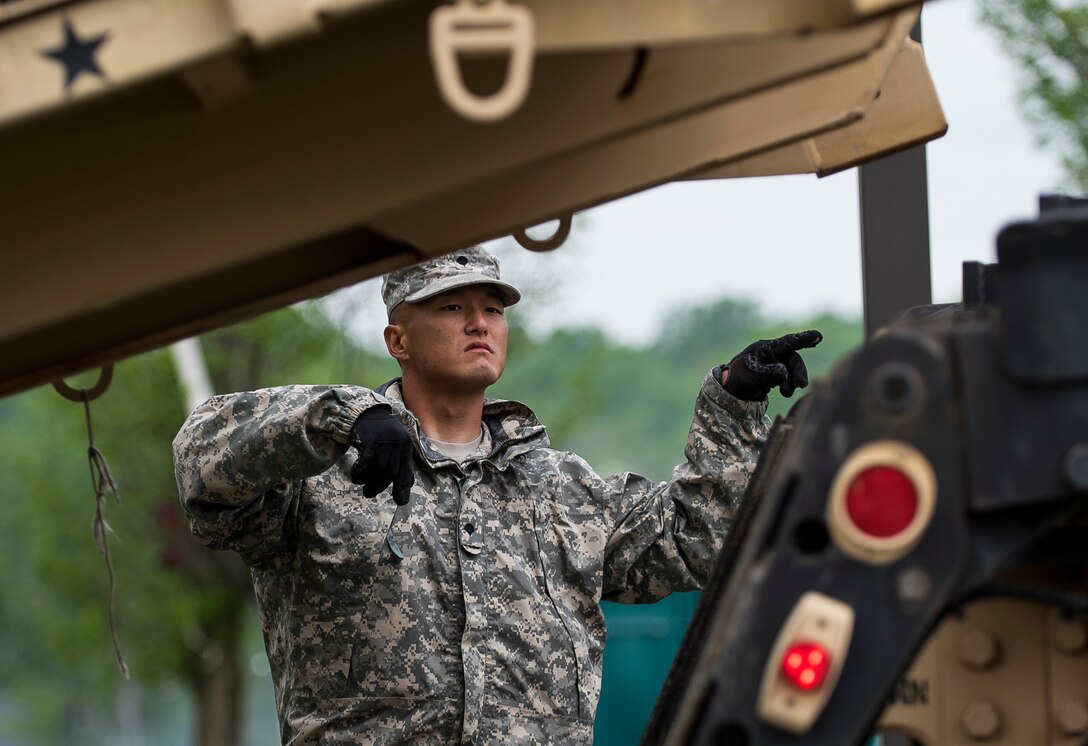 Spc. Phillip Chang, a U.S. Army Soldier with the 51st Chemical Biological Radiological Nuclear Company, of Fort Stewart, Georgia, guides the lowering of a container during Guardian Response 17 at the Muscatatuck Urban Training Center, Indiana, April 27, 2017. Guardian Response, as part of Vibrant Response, is a multi-component training exercise run by the U.S. Army Reserve designed to validate nearly 4,000 service members in Defense Support of Civil Authorities (DSCA) in the event of a Chemical, Biological, Radiological and Nuclear (CBRN) catastrophe. This year's exercise simulated an improvised nuclear device explosion with a source region electromagnetic pulse (SREMP) out to more than 4 miles. The 84th Training Command is the hosting organization for this exercise, with the training operations run by the 78th Training Division, headquartered in Fort Dix, New Jersey. (U.S. Army Reserve photo by Master Sgt. Michel Sauret)