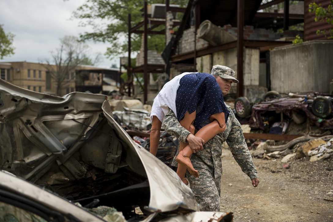 Sgt. 1st Class John Hawes, a U.S. Army Reserve Soldier supporting the 78th Training Division, carries a medical mannequin for a casualty collection point during Guardian Response 17 at the Muscatatuck Urban Training Center, Indiana, April 27, 2017. Guardian Response, as part of Vibrant Response, is a multi-component training exercise run by the U.S. Army Reserve designed to validate nearly 4,000 service members in Defense Support of Civil Authorities (DSCA) in the event of a Chemical, Biological, Radiological and Nuclear (CBRN) catastrophe. This year's exercise simulated an improvised nuclear device explosion with a source region electromagnetic pulse (SREMP) out to more than 4 miles. The 84th Training Command is the hosting organization for this exercise, with the training operations run by the 78th Training Division, headquartered in Fort Dix, New Jersey. (U.S. Army Reserve photo by Master Sgt. Michel Sauret)