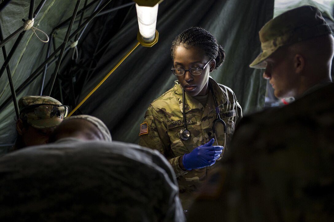 Spc. Cerelia Spencer, a U.S. Army medic with the 602nd Area Support Medical Company, of Fort Bragg, North Carolina, helps with treating a patient during Guardian Response 17 at the Muscatatuck Urban Training Center, Indiana, April 27, 2017. Guardian Response, as part of Vibrant Response, is a multi-component training exercise run by the U.S. Army Reserve designed to validate nearly 4,000 service members in Defense Support of Civil Authorities (DSCA) in the event of a Chemical, Biological, Radiological and Nuclear (CBRN) catastrophe. This year's exercise simulated an improvised nuclear device explosion with a source region electromagnetic pulse (SREMP) out to more than 4 miles. The 84th Training Command is the hosting organization for this exercise, with the training operations run by the 78th Training Division, headquartered in Fort Dix, New Jersey. (U.S. Army Reserve photo by Master Sgt. Michel Sauret)