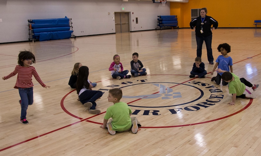 Youth Center children play duck duck goose during an event at the McAdoo Fitness Center at Minot Air Force Base, N.D., April 17, 2017. This group of kindergarteners and first-graders participated in a mock fitness assessment, bounce house, a video exercise with fitness balls and group games. (U.S. Air Force photo/Airman 1st Class Alyssa M. Akers)