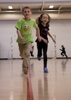 Youth Center children race around basketball courts during a mock fitness assessment at the McAdoo Fitness Center at Minot Air Force Base, N.D., April 17, 2017. The fitness center hosted the event for the children to promote a healthy lifestyle in school-age children. (U.S. Air Force photo/Airman 1st Class Alyssa M. Akers)