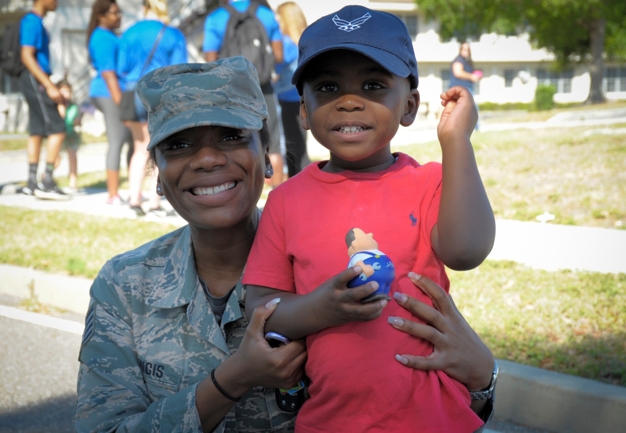 A parent and child pause for a photo after the Month of the Military Child parade at MacDill Air Force Base, Fla., April 21, 2017. Parents throughout the base came out to show their support and walk in the parade with their children. (U.S. Air Force photo by Airman 1st Class Mariette Adams)