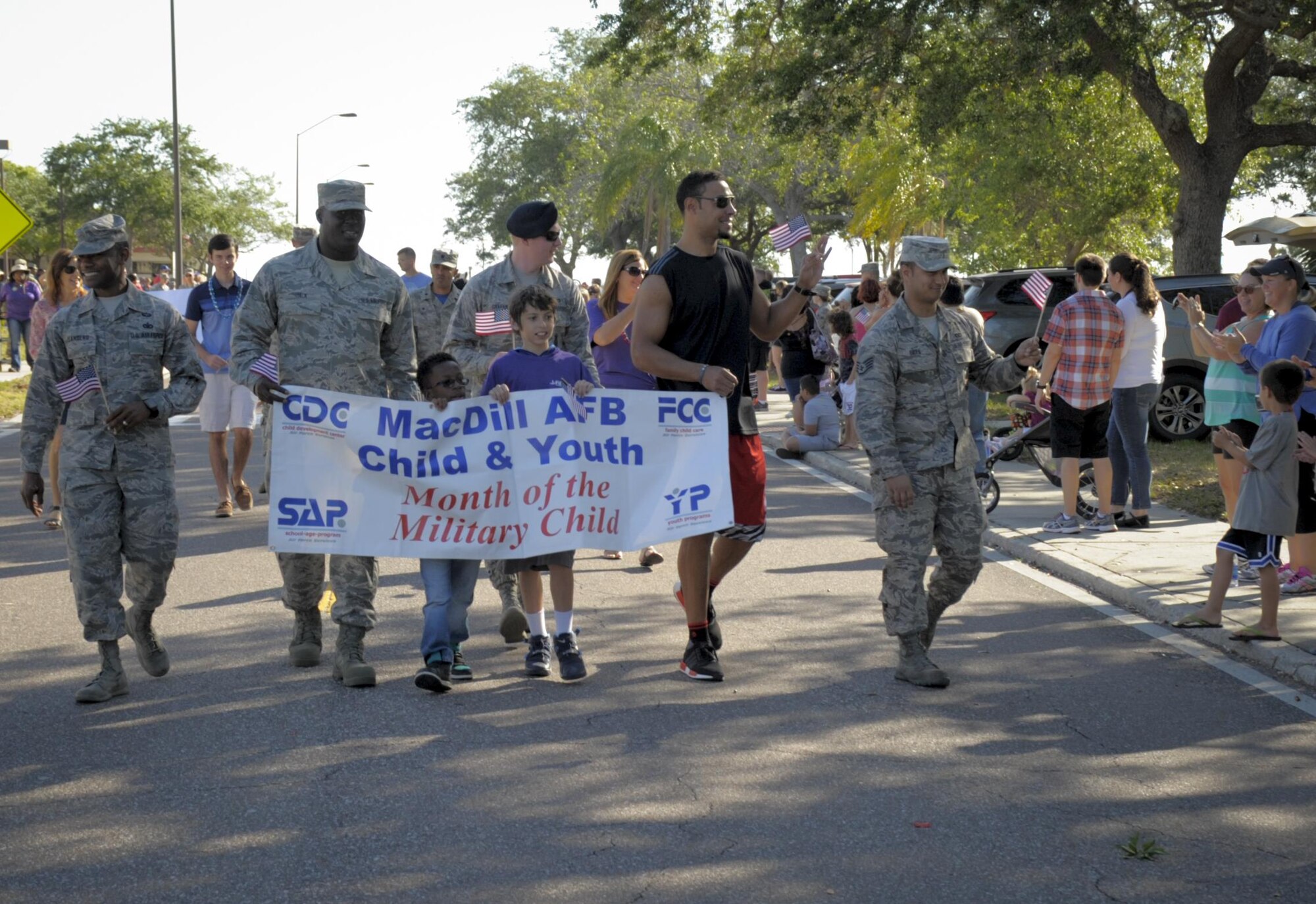 MacDill leadership, military members and children walk in the Month of Military Child parade with special guest Vincent Jackson, a Tampa Bay Buccaneers football player, at MacDill Air Force Base, Fla., April 21, 2017. Team MacDill came together and lined the parade route showing support to their military children. (U.S. Air Force photo by Airman 1st Class Mariette Adams)