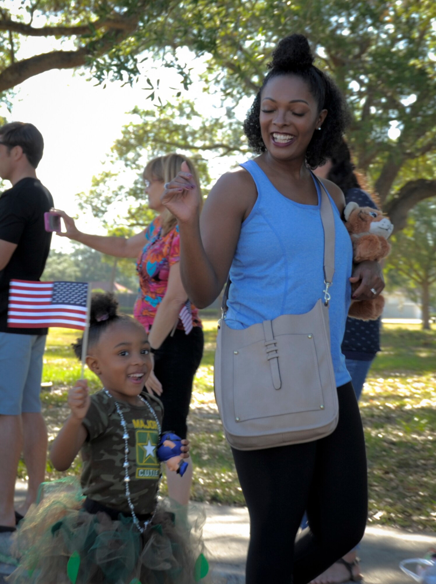 A parent and child walk in the Month of the Military Child parade at MacDill Air Force Base, Fla., April 21, 2017. April is Month of the Military Child and throughout the month MacDill hosted various events in celebration including a parade and numerous school events. (U.S. Air Force photo by Airman 1st Class Mariette Adams)