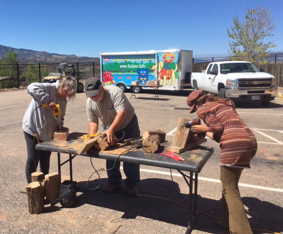 ABIQUIU LAKE, N.M. – Volunteers work on building housing for pollinators during the Pollinator Party at the lake, April 22, 2017. Sixteen volunteers total built housing for pollinators by drilling 3-inch deep, ¼-inch holes in old lumber and brush, putting on a roof and attaching it to a wall or post. 
