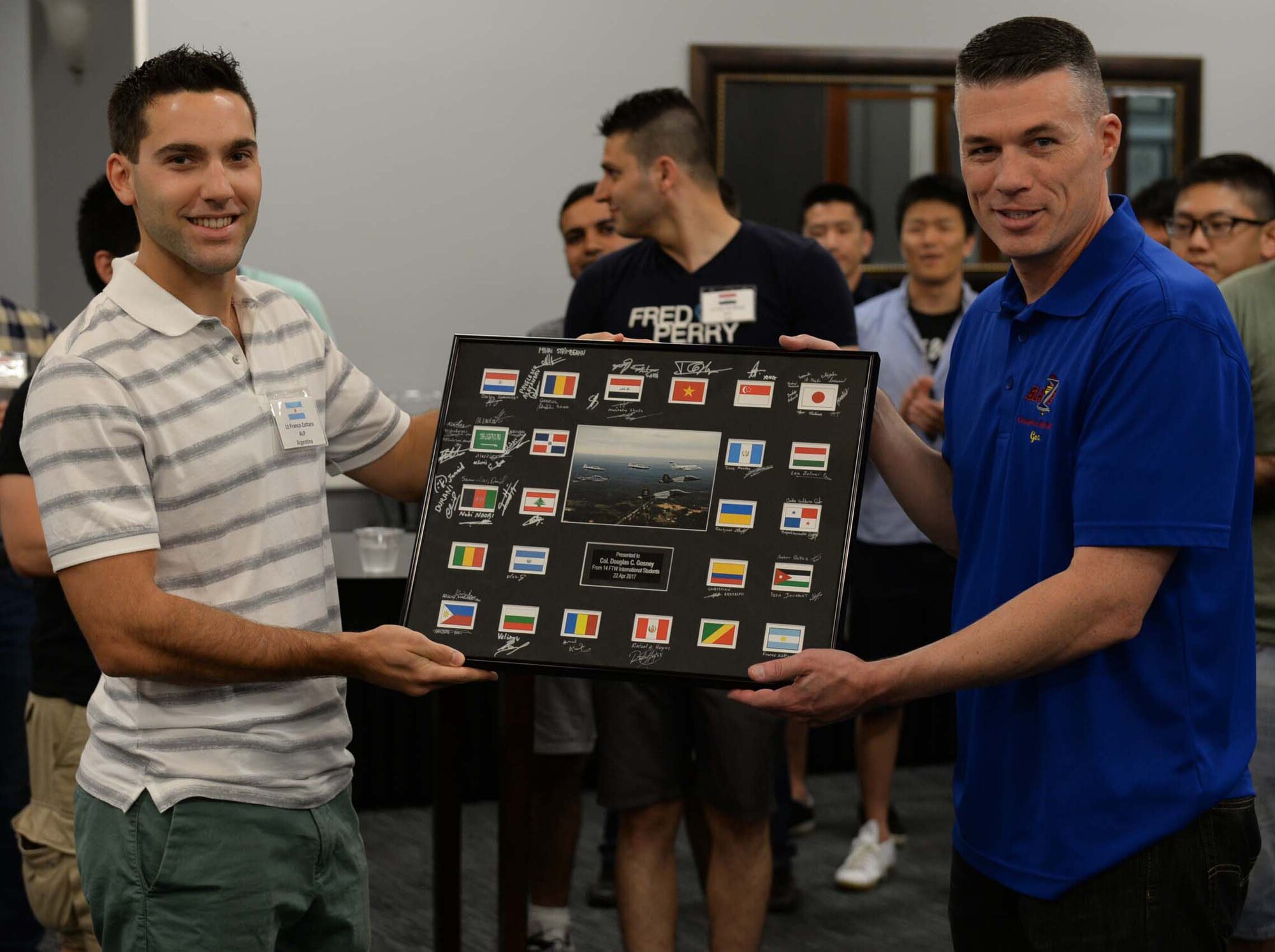 Argentine air force 2nd Lt. Franco Zattara, Aviation Leadership Program student currently flying with Specialized Undergraduate Pilot Training Class 17-13, hands a framed gift to Col. Douglas Gosney, 14th Flying Training Wing Commander, April 22, 2017, at the international student social on Columbus Air Force Base, Mississippi. International students gather once a year to get to know each other and celebrate the partnerships of our air forces.(U.S. Air Force photo by Senior Airman John Day)