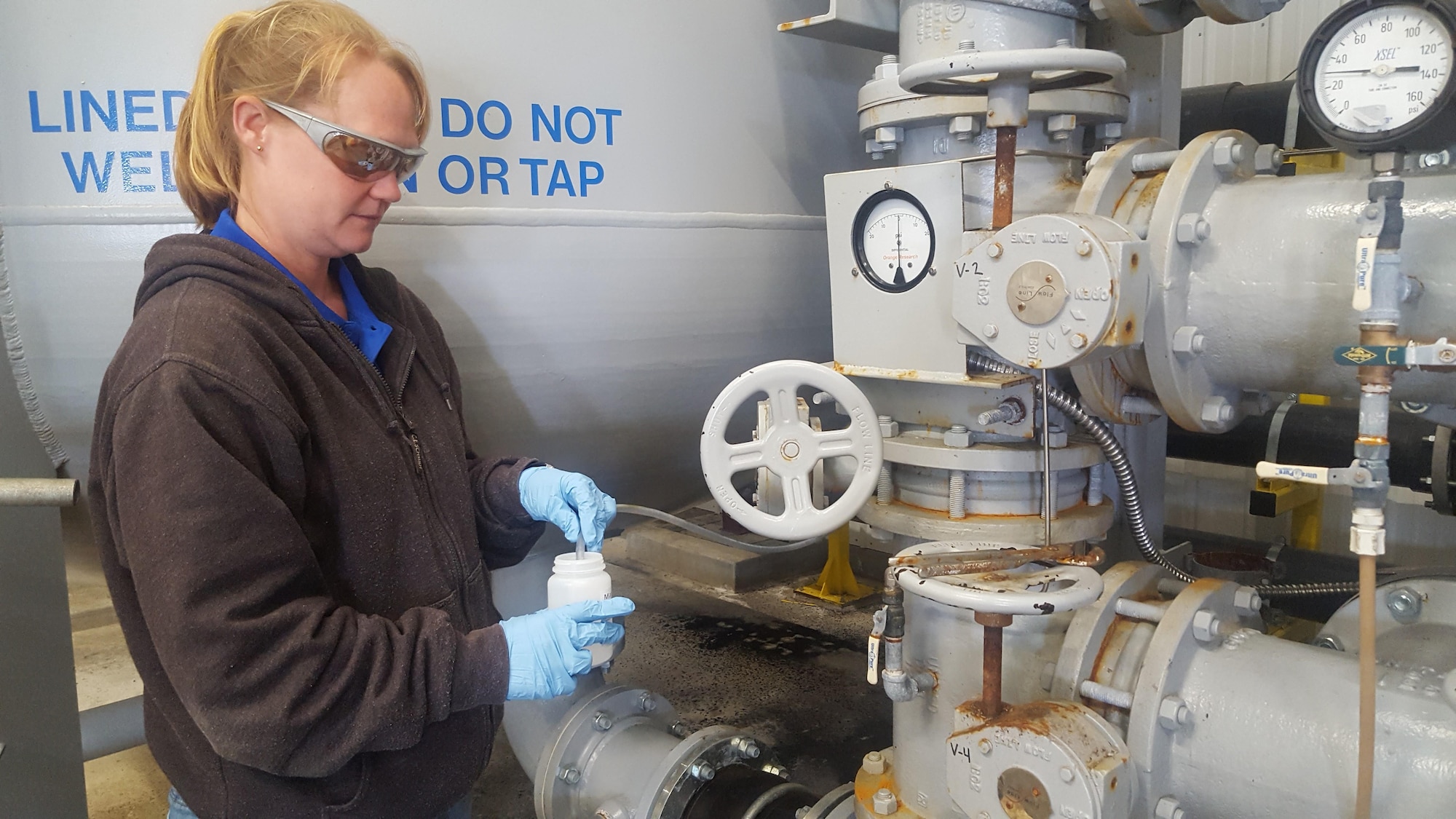 Environmental contractors sample the groundwater from former fire training area #2 at former Wurtsmith Air Force Base, Michigan, several times a month to monitor PFOS/PFOA levels after groundwater passes through various treatment systems. The Air Force installed a Granular Activated Carbon pump and treat system to cut off contaminant discharges from the FTA into Clark’s Marsh in April 2015. Water pumped through the GAC system is sampled once a month. Once a week, the Air Force pulls samples from three remediation systems that are part of a pilot study collecting data to evaluate system performance. These samples are sent to the University of Georgia and Oregon State University where chemical analysis are conducted. (Photo by Breanne Humphreys/ Air Force Photo Released)