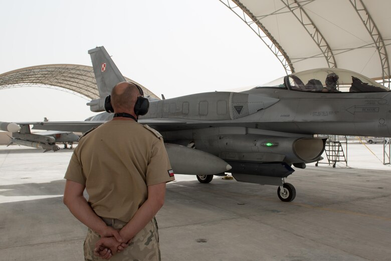 A Polish air force maintainer looks on as an F-16 Fighting Falcon prepares to taxi for a mission at the 407th Air Expeditionary Group, April 24, 2017. The Polish Airmen are part of the 60-nation coalition force supporting Operation Inherent Resolve in the fight against ISIS.  (U.S. Air Force photo/Master Sgt. Benjamin Wilson)(Released)