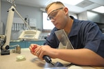 Staff Sgt. Matthew Garcia, 359th Aerospace Medicine Sq., lab technician, works on a orthopedic retainer at Joint Base San Antonio-Randolph Dental clinic, April 25, 2017.  Dental Laboratory specialists assist dentists by crafting and creating custom dental prostheses. These highly skilled experts use the latest tools and techniques and work with dental materials such as acrylic, gypsum and gold to make precision pieces for their patients that they’ll utilize for years to come.  