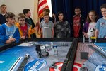 A team of students look on as they test out their final product during Naval Surface Warfare Center, Carderock Division's LEGO Robotics Competition in West Bethesda, Maryland, on April 21, 2017. This is the fourth annual competition Carderock has hosted in which engineers assist elementary and middle school students with the designing and programming of fully-functioning autonomous LEGO robots. (U.S. Navy photo by Jake Cirksena/Released)