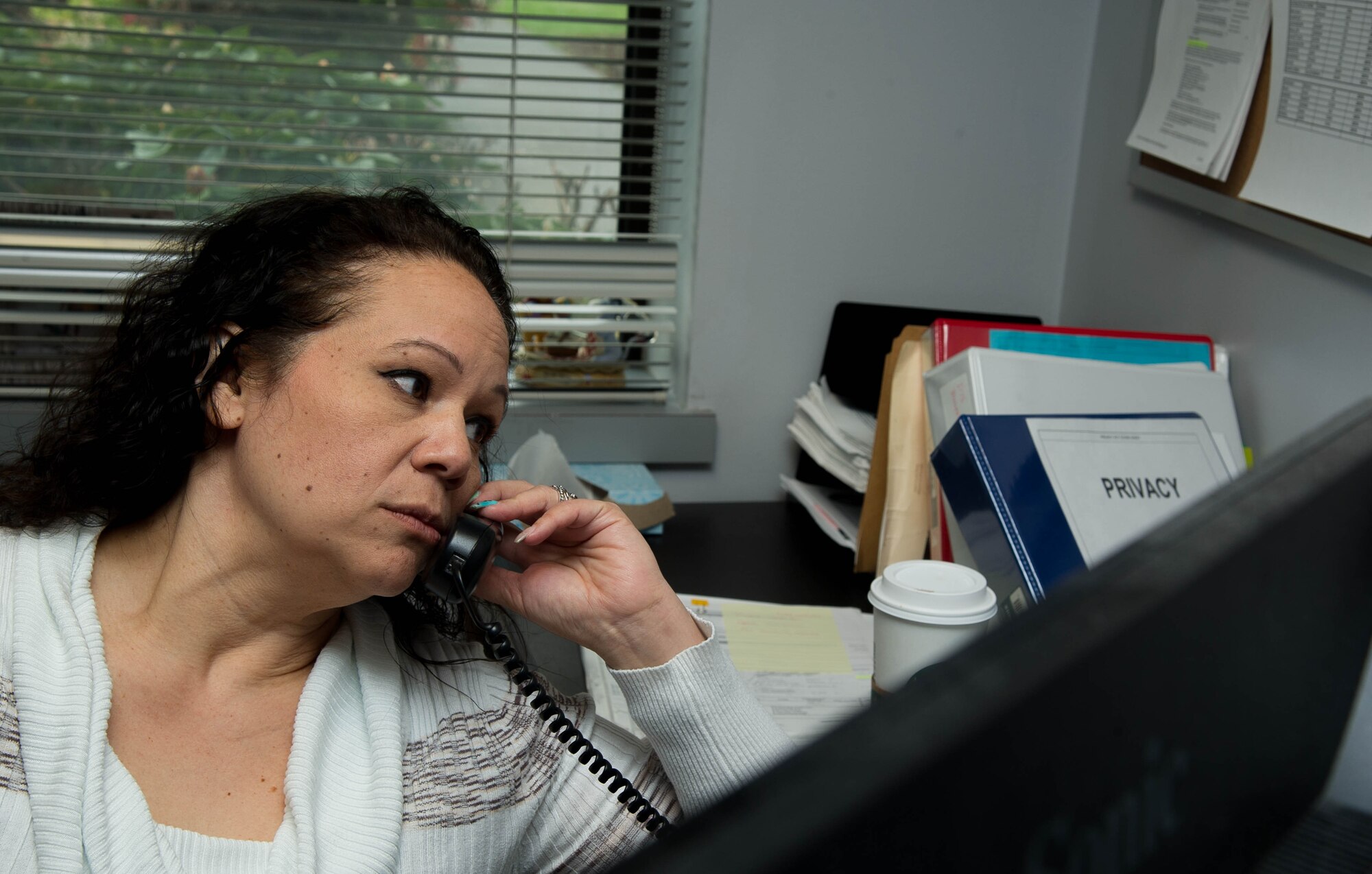 Patricia Gaura answers questions in the 446th Airlift Wing Financial Management Office on Joint Base Lewis-McChord, Wash., on April 24, 2017.  Gaura is one of the technicians that uses eFinance to process travel vouchers. (U.S. Air Force photo by David L. Yost)