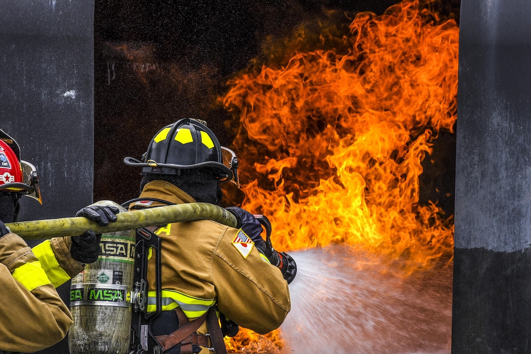 Air Force Senior Airman Antonio Harmon and Tech. Sgt. Michael Gagnier fight a fire during training at Kadena Air Base, Japan, April 26, 2017. Harmon and Gagnier are firefighters assigned to the 18th Civil Engineer Squadron. Air Force photo by Senior Airman Nick Emerick