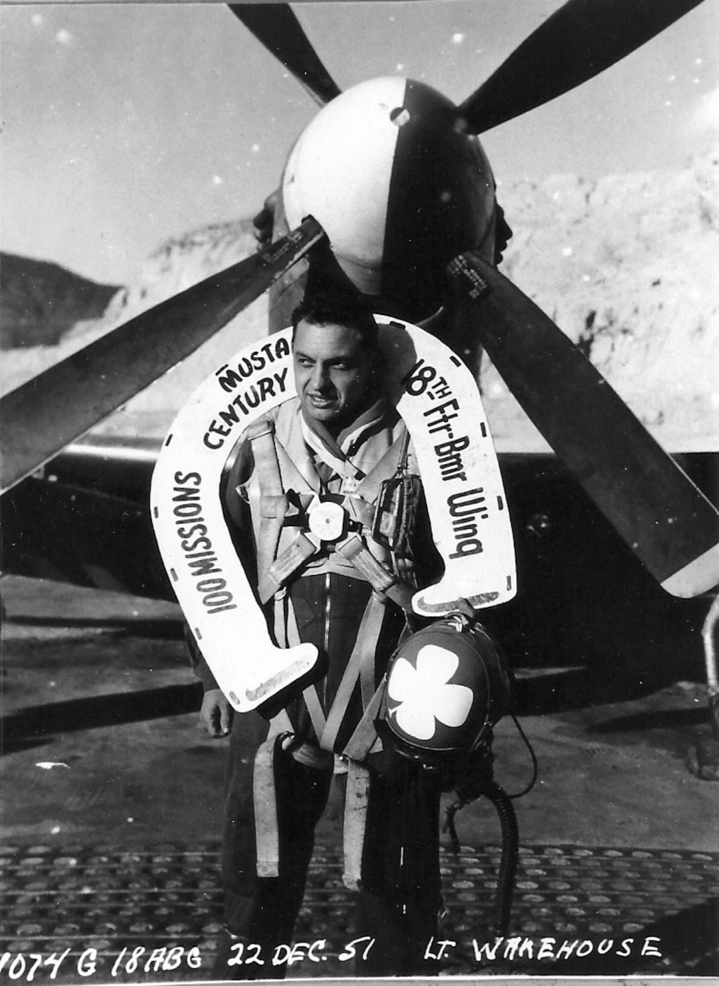 Ernie poses with his “lucky horseshoe” following his 100th mission in Korea.  Helmet is blue with white four-leaf clover.