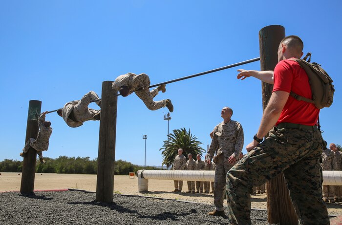 Recruits from Delta Company, 1st Recruit Training Battalion, maneuver over high bars during Obstacle Course II at Marine Corps Recruit Depot San Diego, April 20. If a recruit failed to complete an obstacle the first time, he was sent back to try it again. Annually, more than 17,000 males recruited from the Western Recruiting Region are trained at MCRD San Diego. Delta Company is scheduled to graduate June 30.