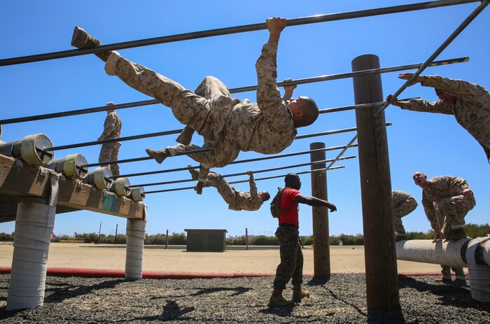 Recruits from Delta Company, 1st Recruit Training Battalion, maneuver a high obstacle during Obstacle Course II at Marine Corps Recruit Depot San Diego, April 20. The recruits were allowed to complete the obstacle by sliding down under a single bar or by pulling themselves up and sliding down two bars. Annually, more than 17,000 males recruited from the Western Recruiting Region are trained at MCRD San Diego. Delta Company is scheduled to graduate June 30.
