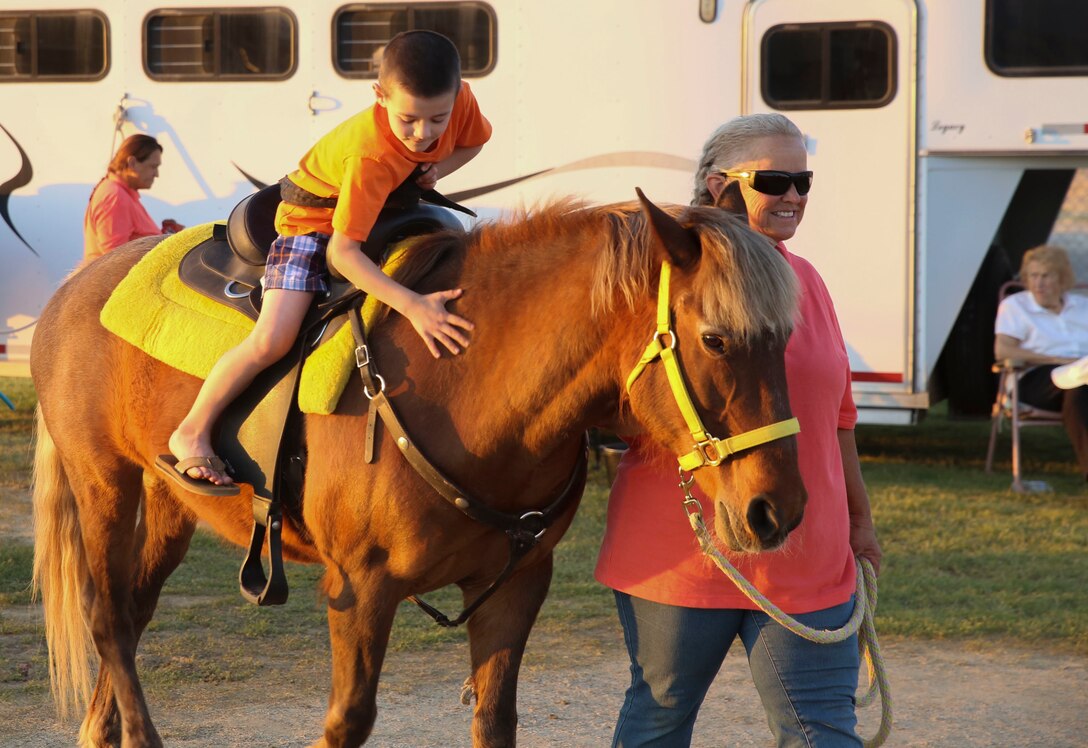 Evan Morrison, son of Staff Sgt. Joshua Morrison, mortarman, 3rd Battalion, 4th Marines, 7th Regiment rides a pony during the Earth Day Extravaganza at Lincoln Military Housing Athletic Field at Marine Corps Air Ground Combat Center Twentynine Palms, Calif., on April 21, 2017.  LMH and Natural Resources and Environmental Affairs hosted the event to make Combat Center patrons more conscious about the environment in a fun and informative way. (U.S. Marine Corps photo by Lance Cpl. Dave Flores)