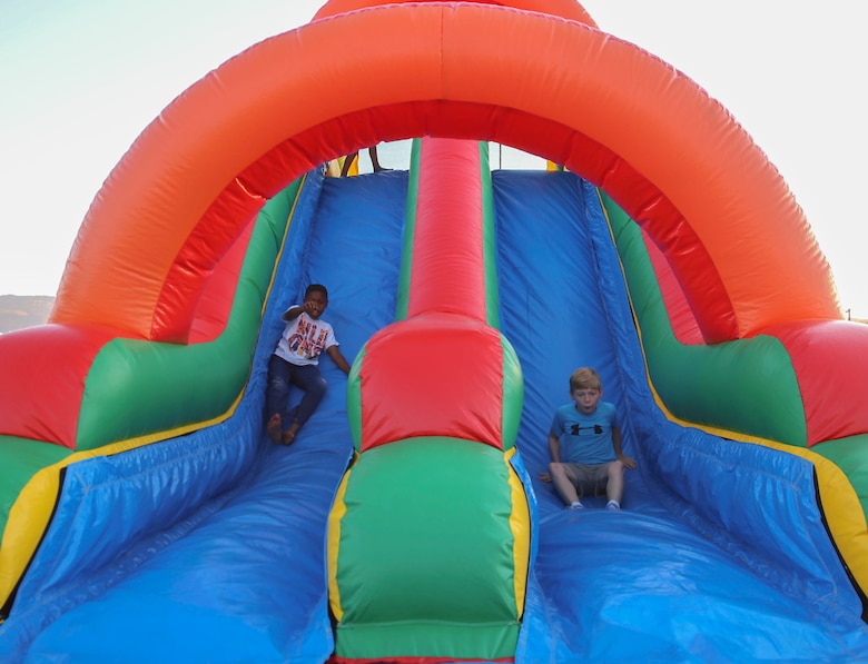 Combat Center children traverse through an inflatable obstacle course during the Earth Day Extravaganza, hosted by Lincoln Military Housing, at the LMH Athletic Field aboard Marine Corps Air Ground Combat Center, Twentynine Palms, Calif., April 21, 2017.  LMH and Natural Resources and Environmental Affairs hosted the event to make Combat Center patrons more conscious about the environment in a fun and informative way. (U.S. Marine Corps photo by Lance Cpl. Dave Flores)