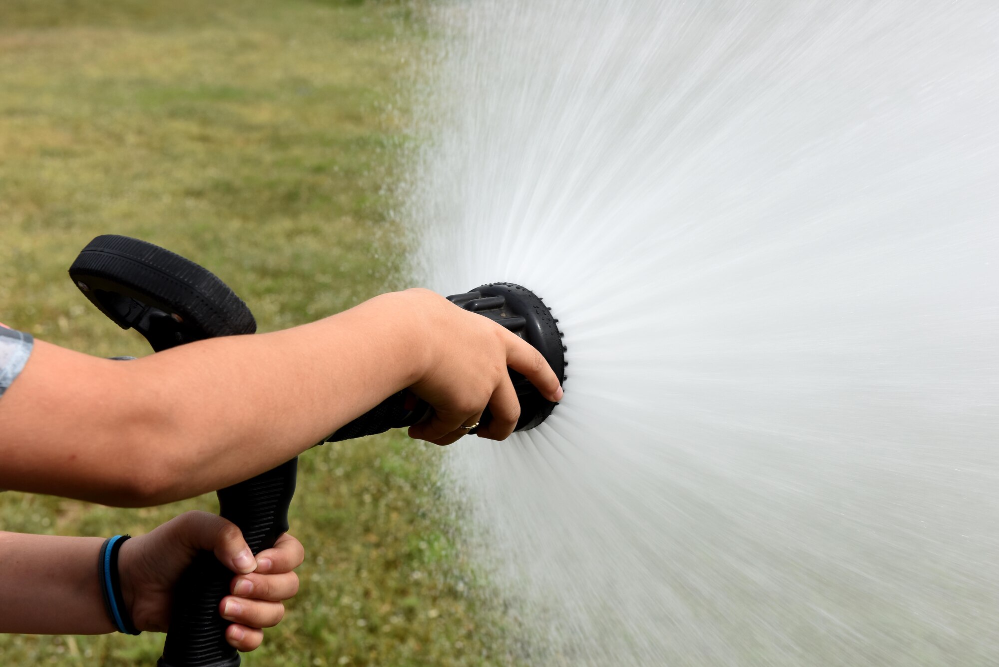 A girl adjusts a fire hose at the Goodfellow fire department on Goodfellow Air Force Base, Texas, April 28, 2017. Holliman Elementary School children were allowed to experience the life of a firefighter with supervision. (U.S. Air Force photo by Airman 1st Class Caelynn Ferguson/ Released)