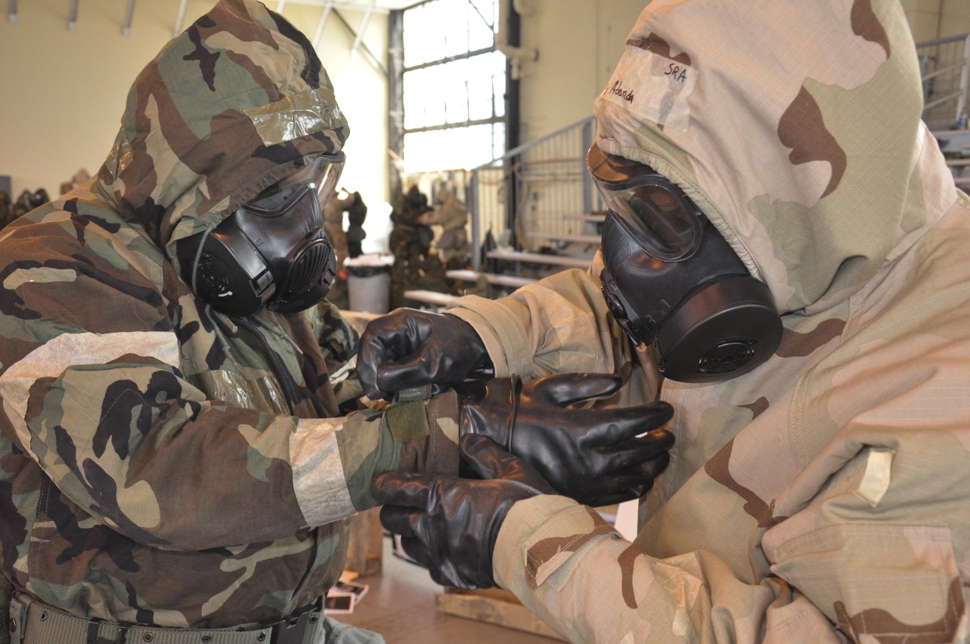 Staff Sgt. Adonda Fondon, with the 908th Logistics Readiness Squadron, helps Tech. Sgt. Shanton Redmon, also with the 908th LRS, secure his gloves during the Basic Deployment Readiness Rodeo March 4, at Maxwell Air Force Base, Ala. The BDR Rodeo was a three day readiness training where Air Force personnel practiced a number of predeployment activities to include Chemical, Biological, Radioactive, and Nuclear preparedness training. (U.S. Air Force photo by Staff Sgt. Malia Belton)