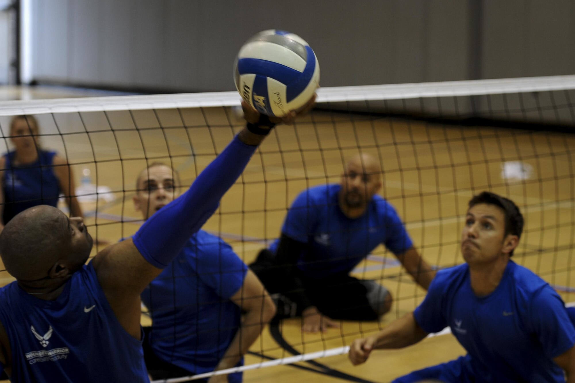 Larry O'Neil, a member of the Air Force sitting volleyball team, reaches back to set the volleyball at Hurlburt Field, Fla., April 24, 2017. Players participated in a variety of drills and a scrimmage game. (U.S. Air Force photo by Airman 1st Class Dennis Spain)