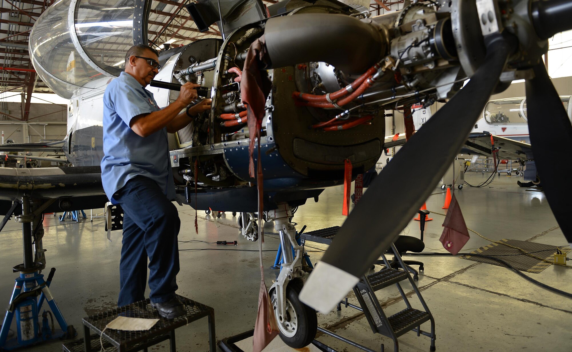 Raul Castaneda, 47th Maintenance Directorate maintainer, inspects the engine bay of a T-6 Texas II on Laughlin Air Force Base, Texas, April 12, 2017. Castaneda is part of the maintenance crew that restored Laughlin’s hangar queens, putting Laughlin at the top of Air Education and Training Command with the least amount of T-6 hangar queens. A “hangar queen” is an aircraft that hasn’t been flown in more than 30 days. (U.S. Air Force photo/Airman 1st Class Benjamin N. Valmoja)