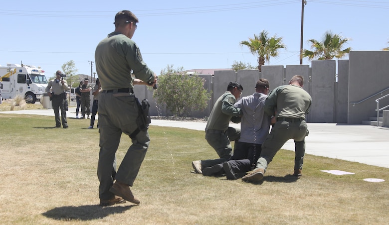 Special Reaction Team members, Provost Marshals Office, subdue Agent Cody Cunningham, criminal investigator, Criminal Investigations Division, with an X26P Taser during PMO’s annual Community Safety Event at Victory Field aboard Marine Corps Air Ground Combat Center, Twentynine Palms, Calif., April 21, 2017. PMO hosted the event to educate the community on various programs and strengthen community based partnerships. (U.S. Marine photo by Lance Cpl. Natalia Cuevas)