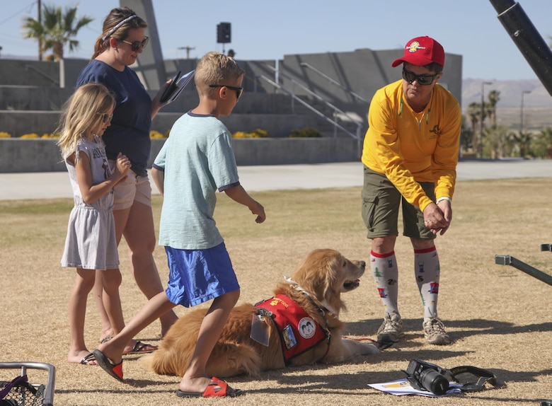 Laura Finlon, Joshua Tree Search and Rescue team member, introduces Gunner, comfort dog, to Combat Center patrons during the Provost Marshal’s Office annual Community Safety Event at Victory Field aboard Marine Corps Air Ground Combat Center, Twentynine Palms, Calif., April 21, 2017. PMO hosted the event to educate the community on various programs and strengthen community based partnerships. (U.S. Marine photo by Lance Cpl. Natalia Cuevas)