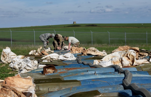 Members of 22nd Civil Engineer Squadron’s Explosive Ordinance Disposal flight adhere explosive cutting tape to inert munitions April 25, 2017, at Smoky Hill Air National Guard Range, Salina, Kan. The ECT was detonated and used to cut into the bombs in order for them to be disposed of properly. (U.S. Air Force photo/Airman 1st Class Erin McClellan)