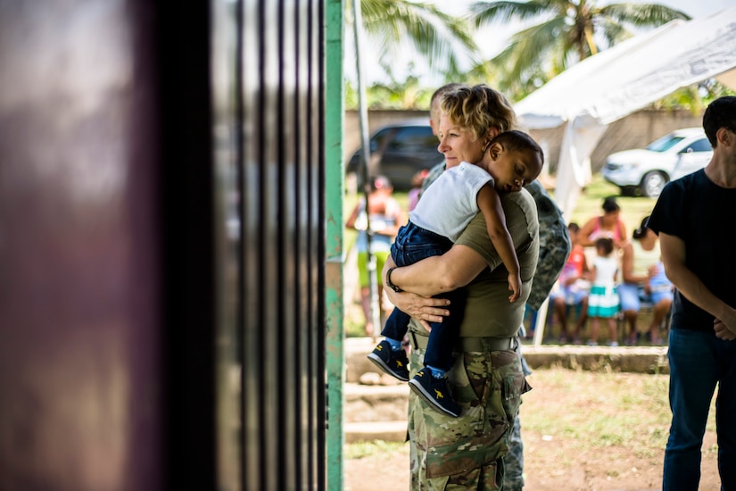 U.S. Army Sgt. 1st Class Lorraine Branson comforts a Honduran child while waiting for medical care at a Medical Readiness Training Exercise site at Cooperativa village, Colon, Honduras , Apr. 20, 2017. Joint Task Force – Bravo Medical Element, provided care to more than 850 patients during a Medical Readiness Training Exercise in Cooperativa village, Colon, Honduras, Apr. 20-21, 2017. MEDEL also supported a Military Partnership Engagement and assisted more than 650 patients with the Hondurian Navy in Santa Rosa de Aguan, Colon, Honduras, Apr. 22, 2017. (U.S. Air National Guard photo by Master Sgt. Scott Thompson/released)
