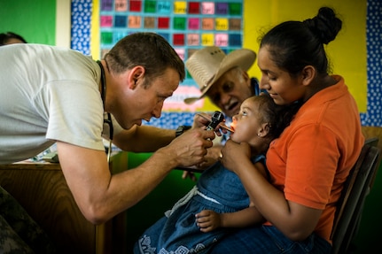 U.S. Army Capt. Adam West checks the throat of a Honduran child at a Military Partnership Engagement in Santa Rosa de Aguan, Colon, Honduras, Apr. 22, 2017. Joint Task Force – Bravo Medical Element, provided care to more than 850 patients during a Medical Readiness Training Exercise in Cooperativa village, Colon, Honduras, Apr. 20-21, 2017. MEDEL also supported a Military Partnership Engagement and assisted more than 650 patients with the Hondurian Navy in Santa Rosa de Aguan, Colon, Honduras, Apr. 22, 2017. (U.S. Air National Guard photo by Master Sgt. Scott Thompson/released)