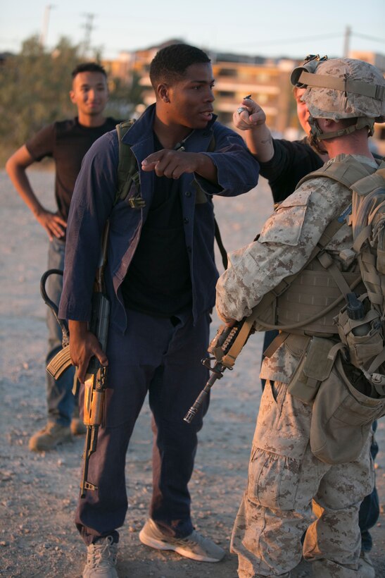 Cpl. Brandon Armwood, roleplayer, Tactical Training Exercise Control Group, interacts with a Marine from 2nd Battalion, 6th Marine Regiment during a non-combatant Evacuation Operation exercise as part of Weapons and Tactics Instructor Course 2-17 aboard Marine Corps Air Ground Combat Center Twentynine Palms, Calif., April 21, 2017. NEO exercises simulate real-life scenarios where non-combatants are evacuated from a potentially hostile area. (U.S. Marine Corps photo by Cpl. Julio McGraw)