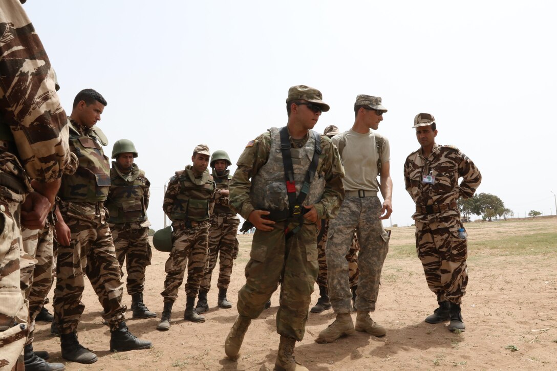 Army Pv2 Byren Latza and Army Sgt. Vincent Nutter, military policemen with the 805 MP Company in Cary, North Carolina, demonstrate how to equip a gunner’s harness to the Royal Moroccan Armed Forces at Tifnit, Morocco, on April 22, 2017, during Exercise African Lion. Exercise African Lion is an annually scheduled, combined multilateral exercise designed to improve interoperability and mutual understanding of each nation’s tactics, techniques and procedures. 