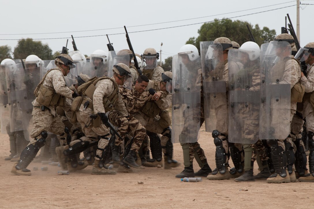 Marines with Marine Company B, 4th Law Enforcement Battalion, Soldiers with the 805th Military Police Company, and Royal Moroccan Armed Forces subdue the leader of the pseudo-rioters as part of crowd control training during Exercise African Lion in Tifnit, Morocco, on April 24, 2017. Exercise African Lion is an annually scheduled, combined multilateral exercise designed to improve interoperability and mutual understanding of each nation’s tactics, techniques and procedures.